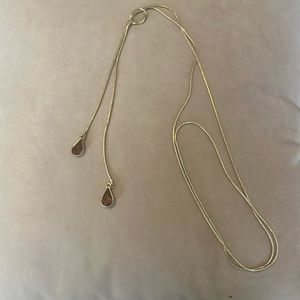 Dark orange jewel drop necklace with knot detail.